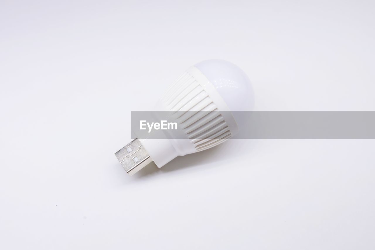 Close-up of light bulb against white background