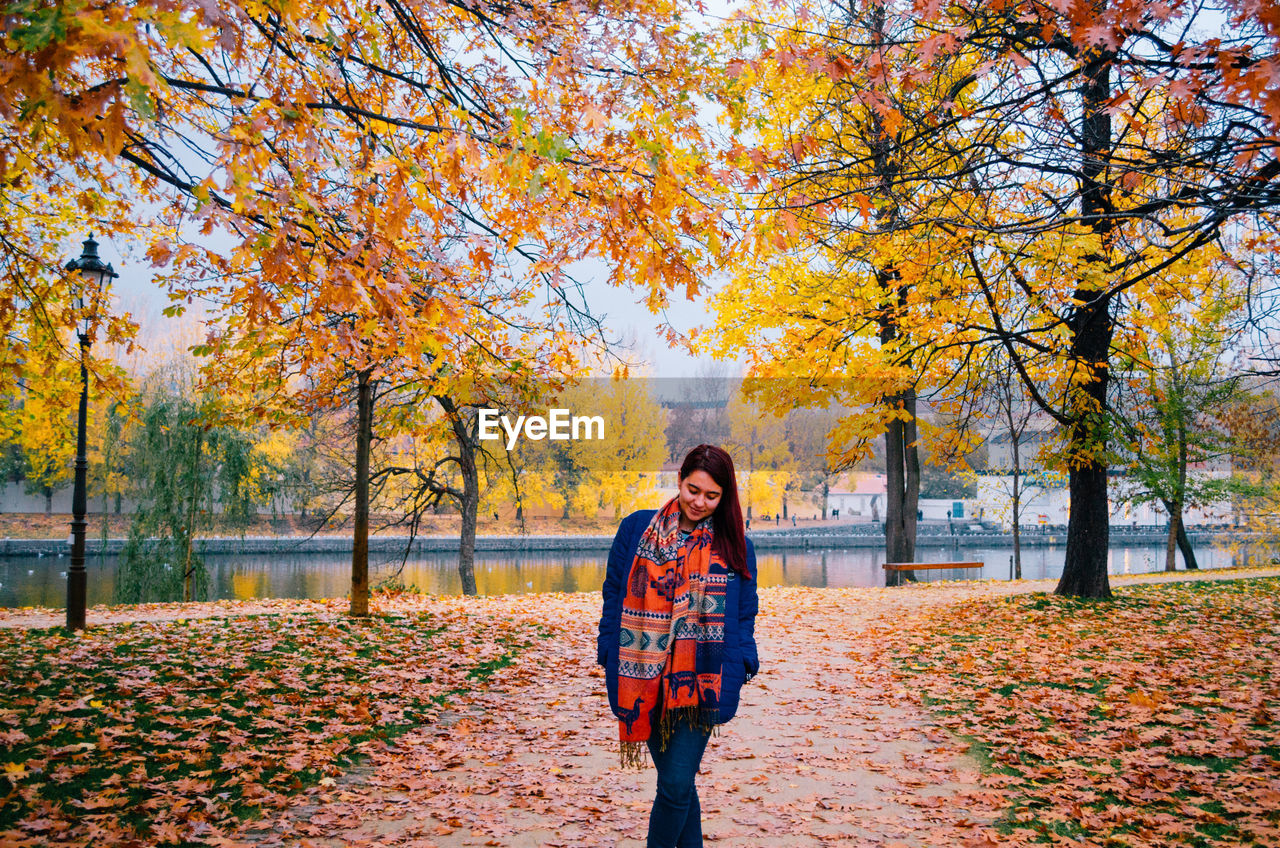 Woman standing by trees during autumn