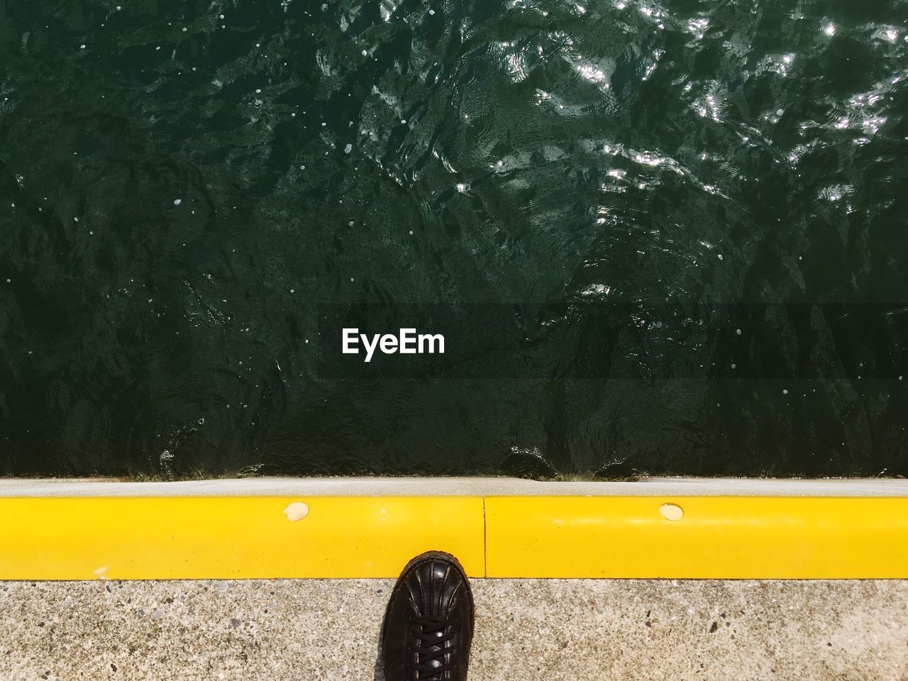 Low section of person by marking over sea