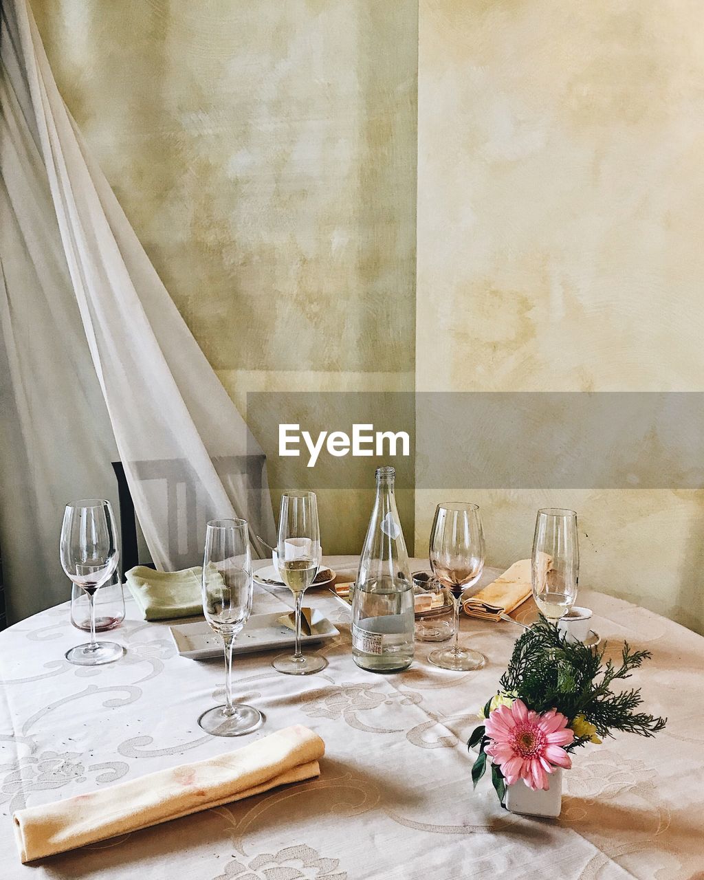 VIEW OF DINING TABLE WITH FLOWERS IN FOREGROUND