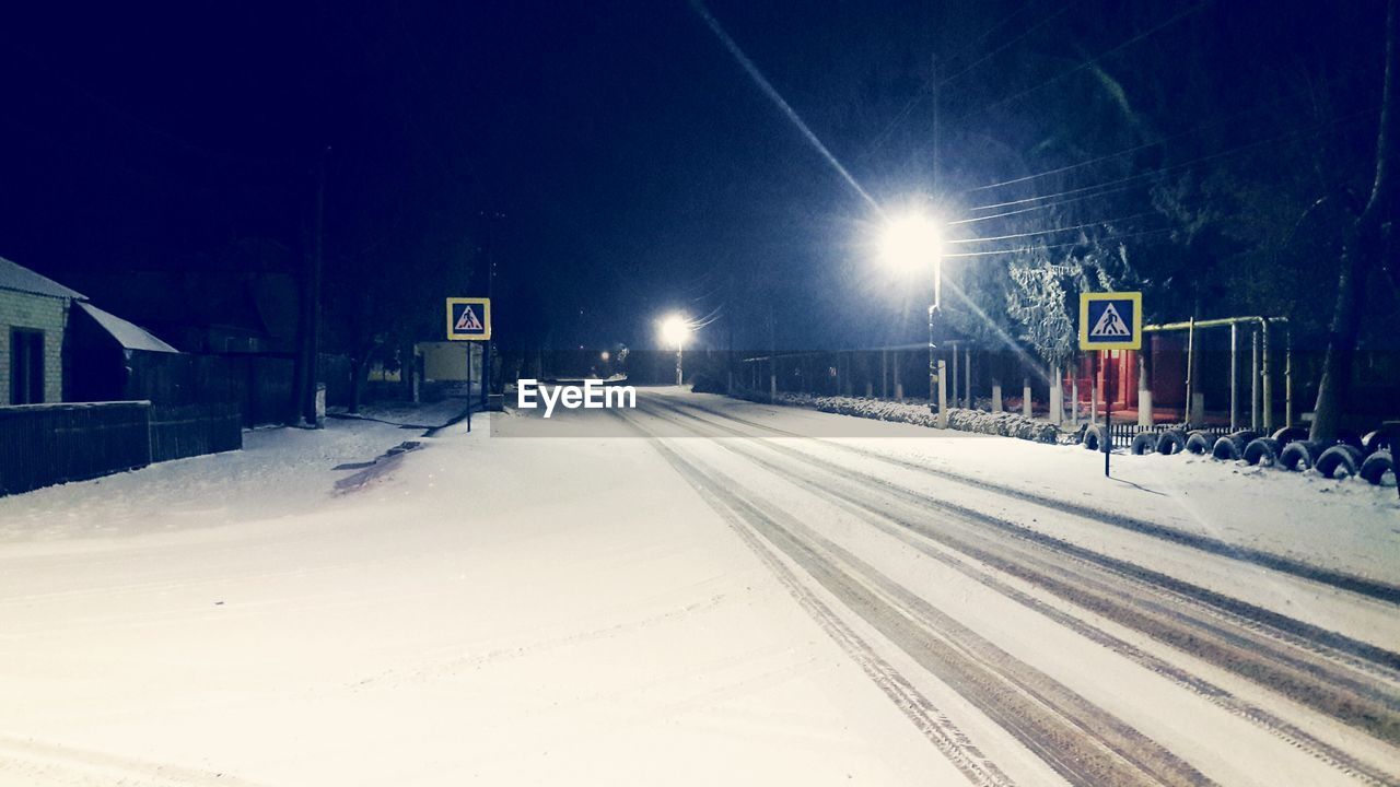 Snow covered railroad tracks against sky during winter