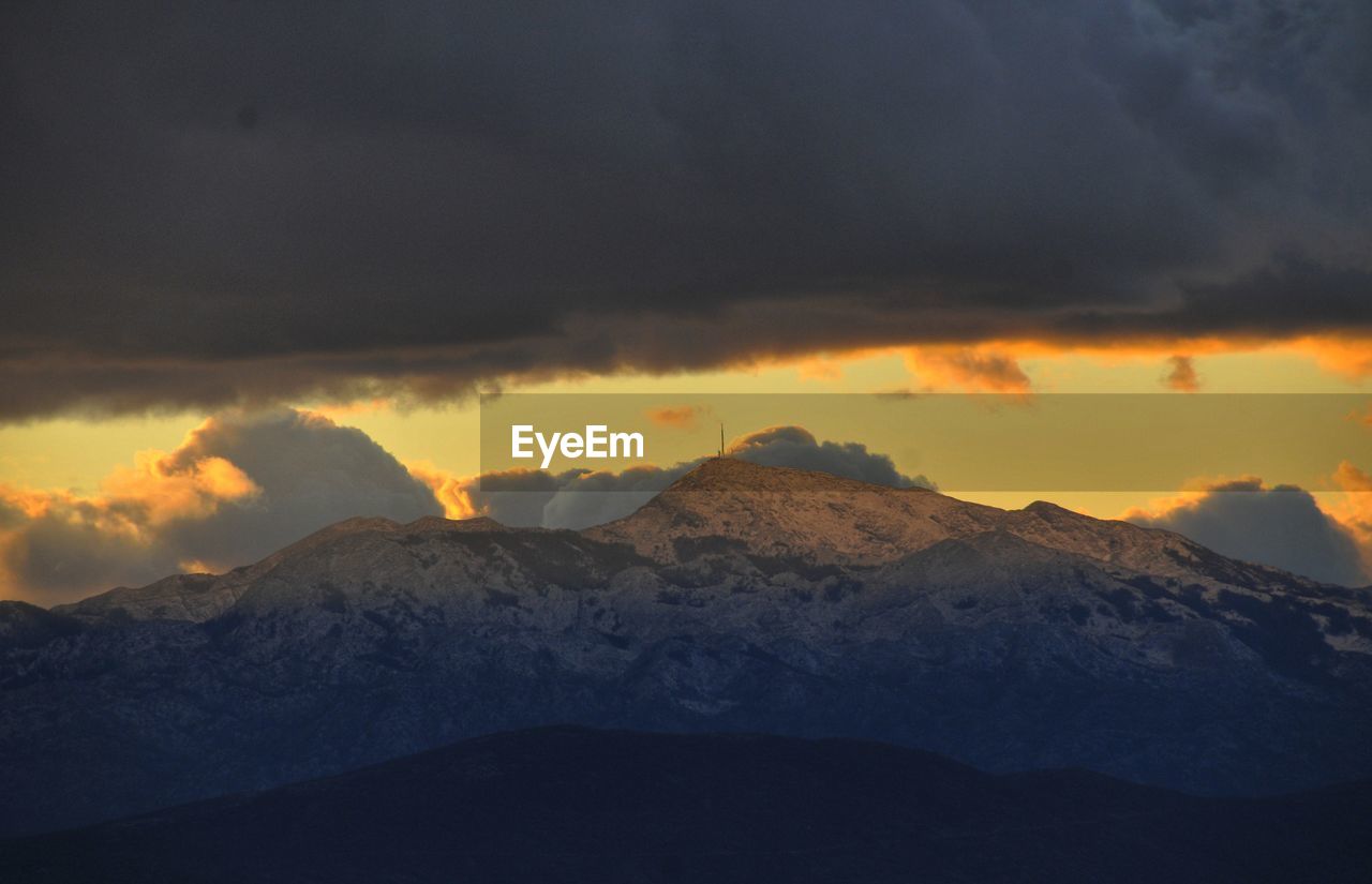 Scenic view of snowcapped mountains against sky during sunset