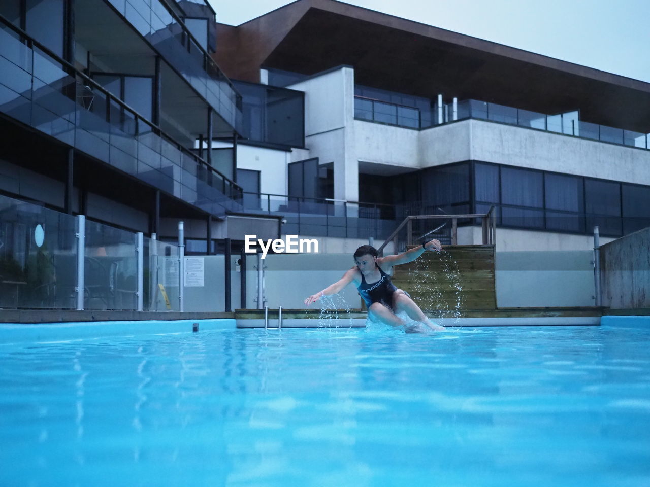 FULL LENGTH OF WOMAN WITH SWIMMING POOL