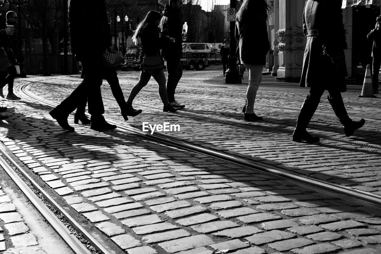 LOW SECTION OF PEOPLE WALKING ON RAILROAD TRACK