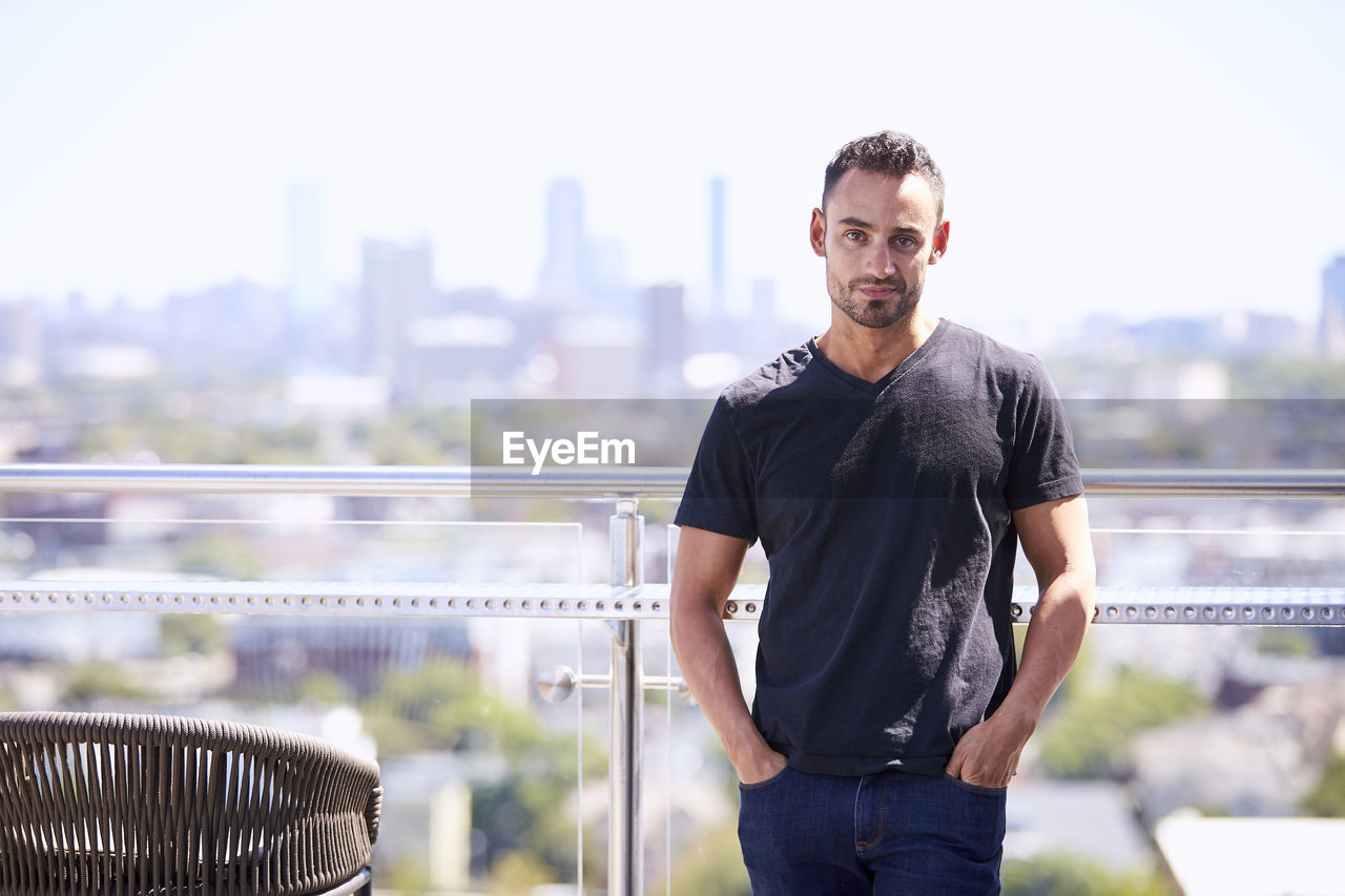 An outdoor portrait of a man with a city view.