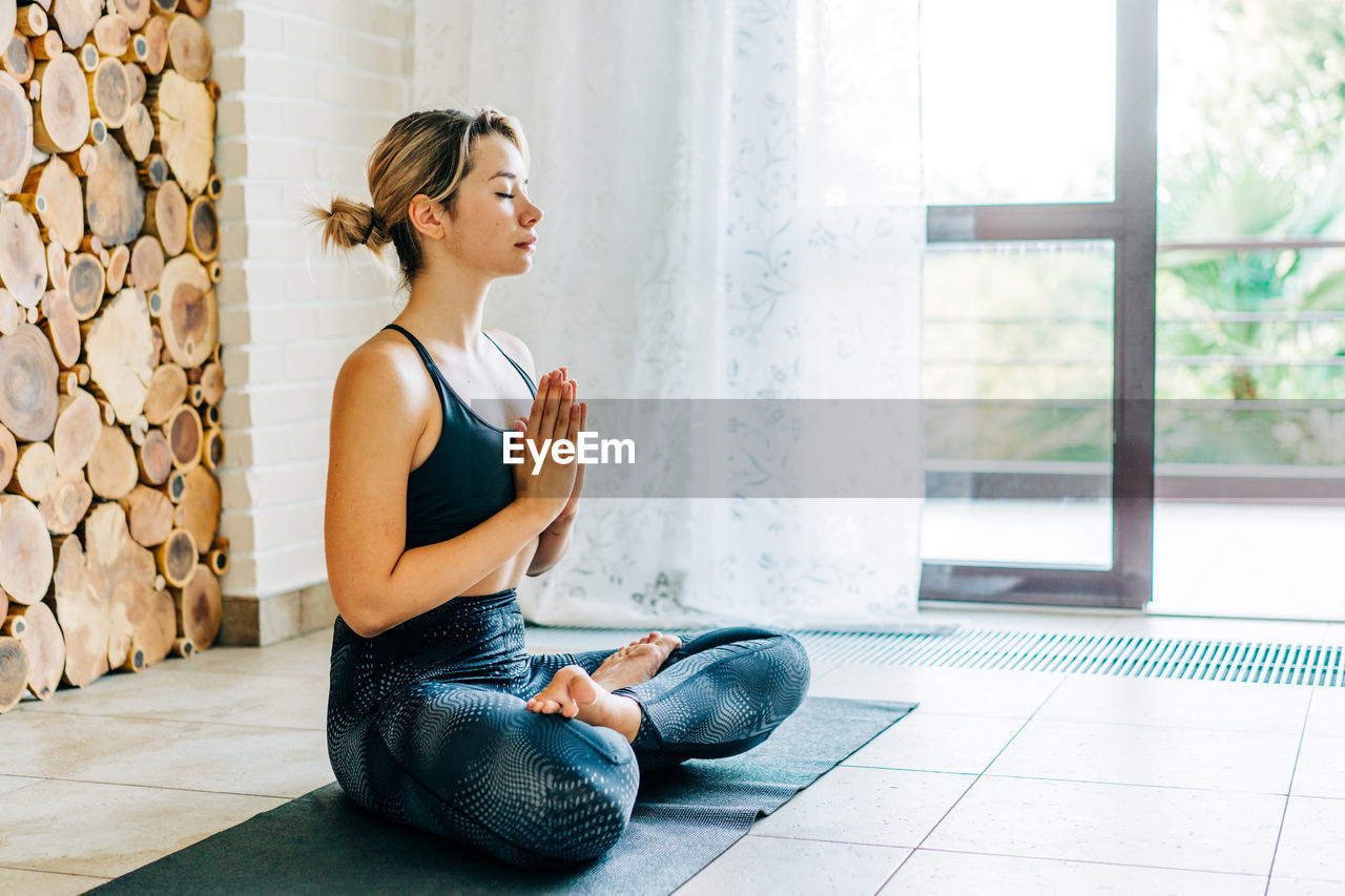 Young woman meditating at home