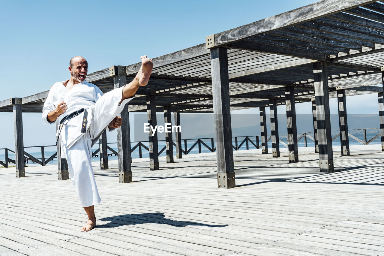 Karate man practicing a kick in the air.