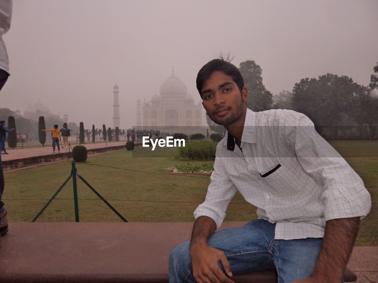 PORTRAIT OF YOUNG MAN STANDING IN CITY AGAINST SKY