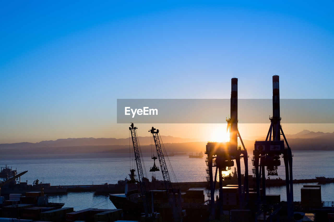 Silhouette view of cranes at port facilities at dawn, valparaiso, valparaiso region, chile.