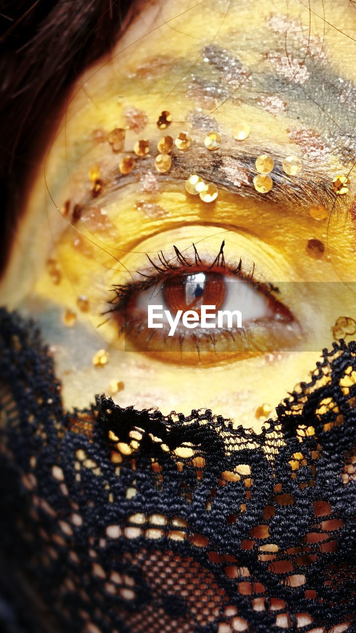 Close-up of human eye with yellow and golden make-up