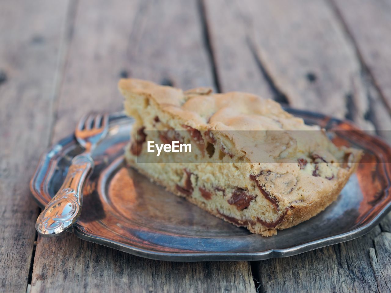 The benefits of dried fruit. a piece of homemade apple pie with chips or slices on a metal plate 