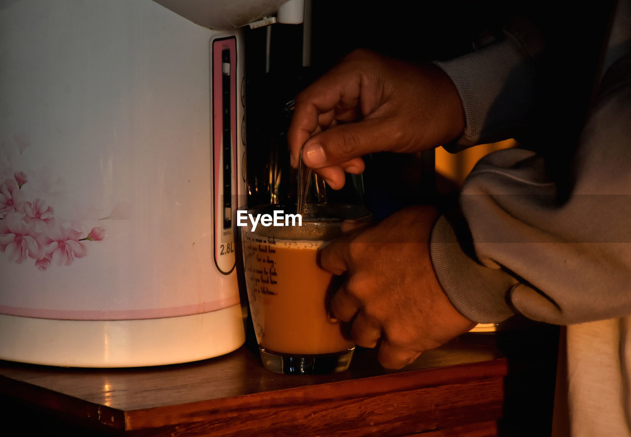 CLOSE-UP OF MAN HOLDING COFFEE CUP