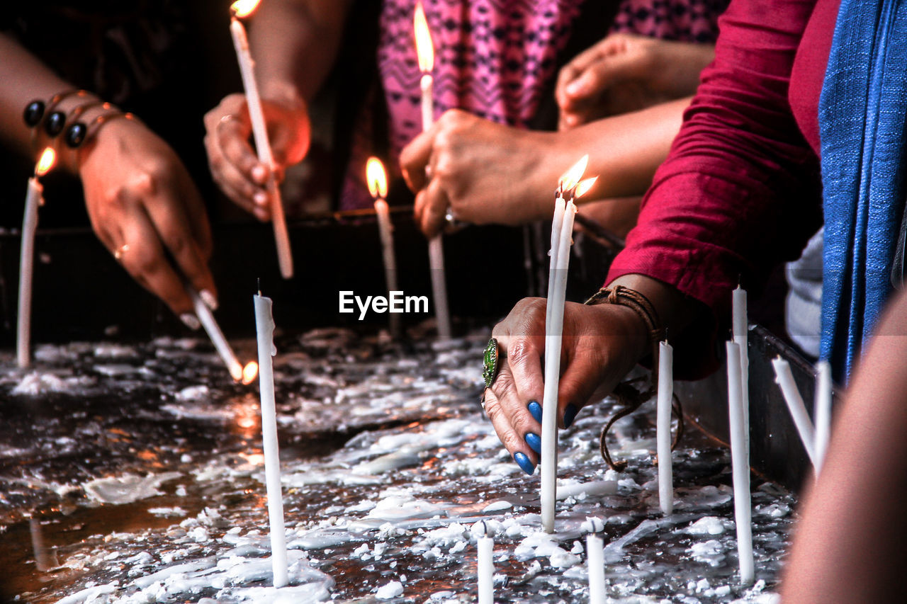 Close-up of hands holding candles
