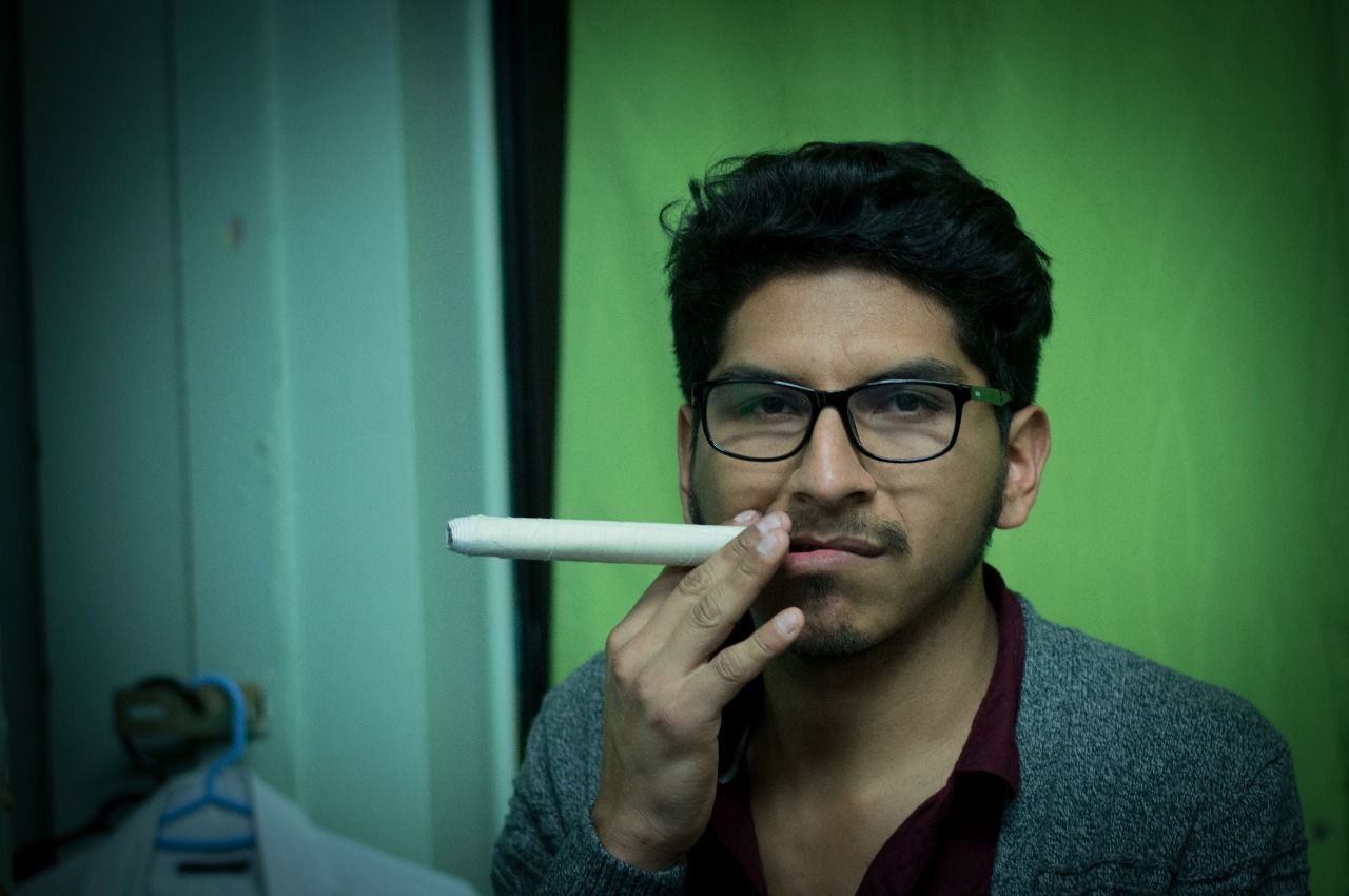 CLOSE-UP PORTRAIT OF MAN SMOKING CIGARETTE