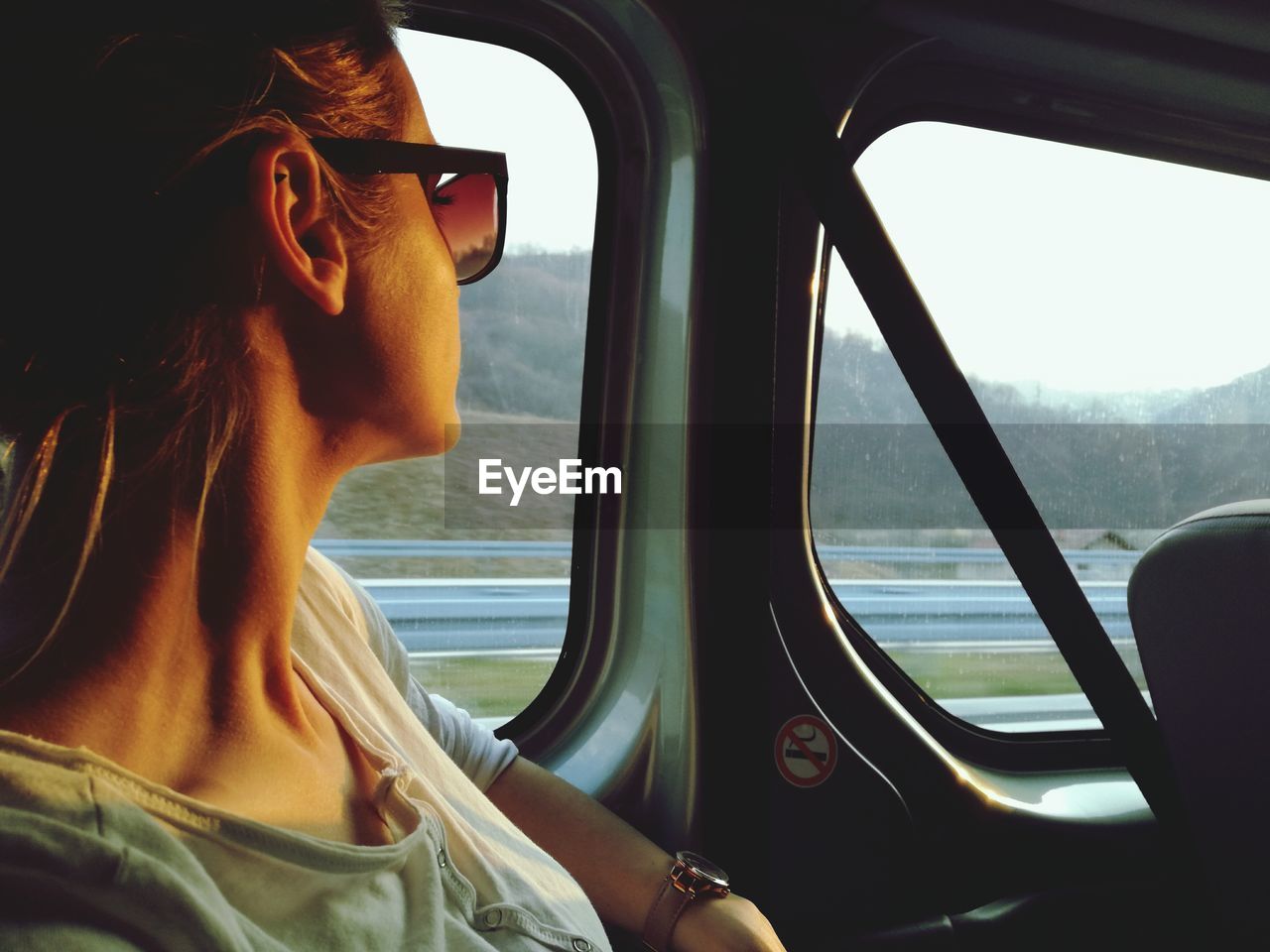 Close-up of woman looking through window while travelling in vehicle