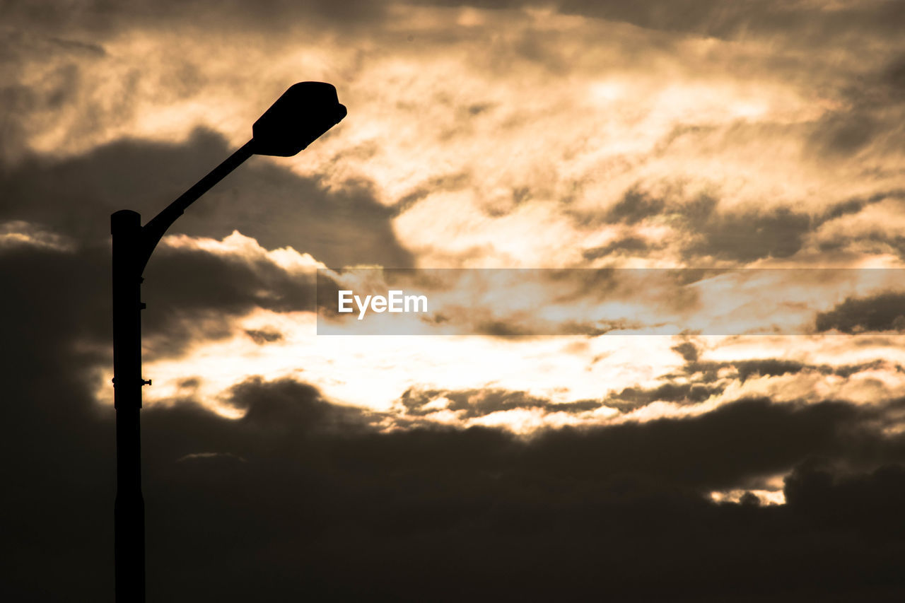 Low angle view of silhouette street light against sky