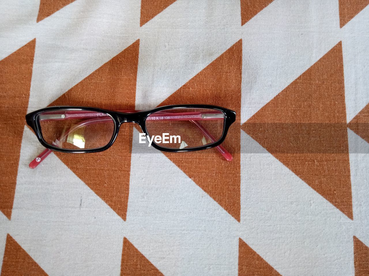 CLOSE-UP OF SUNGLASSES AGAINST BLACK BACKGROUND