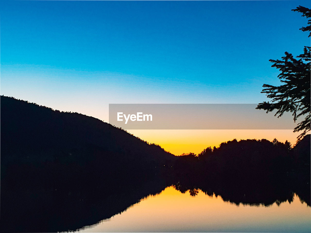 SCENIC VIEW OF LAKE AGAINST SKY AT SUNSET