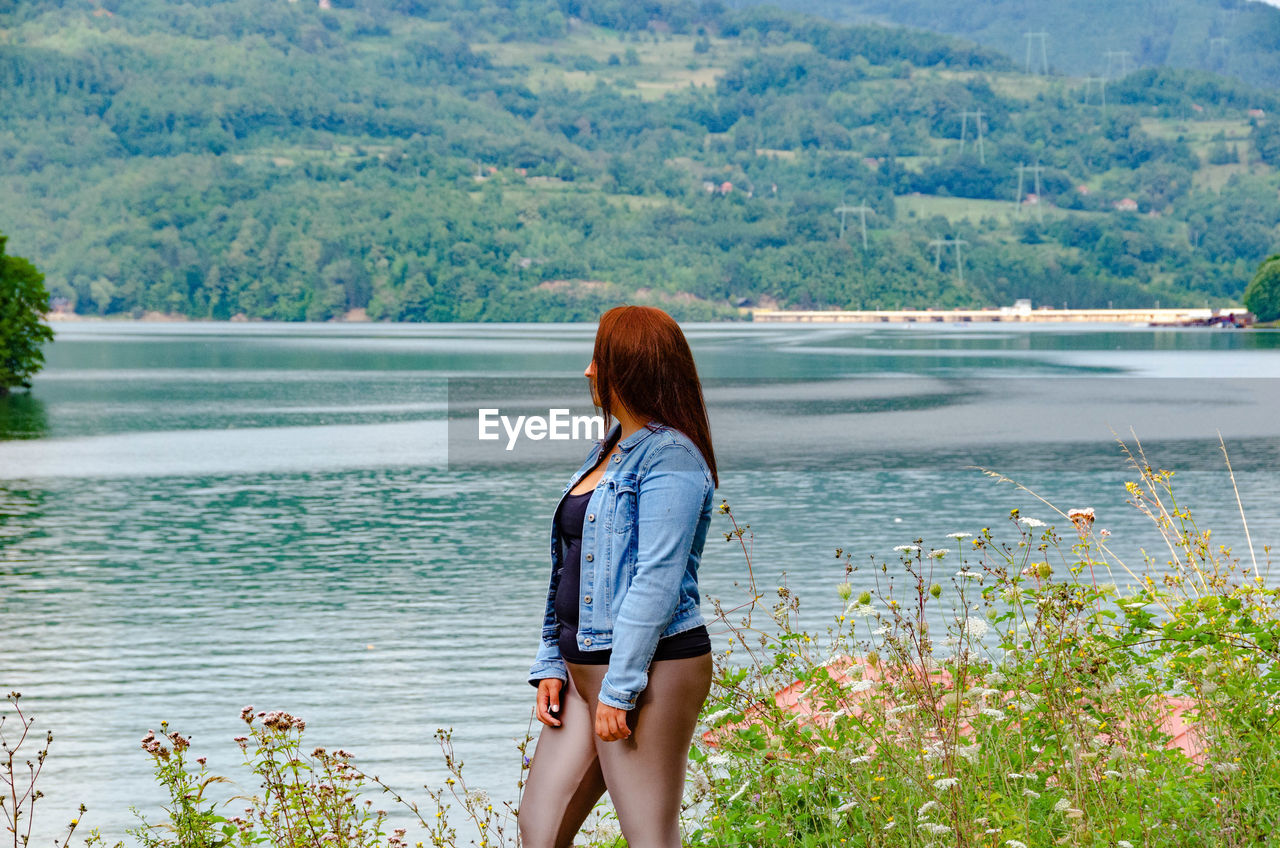FULL LENGTH REAR VIEW OF WOMAN LOOKING AT LAKE