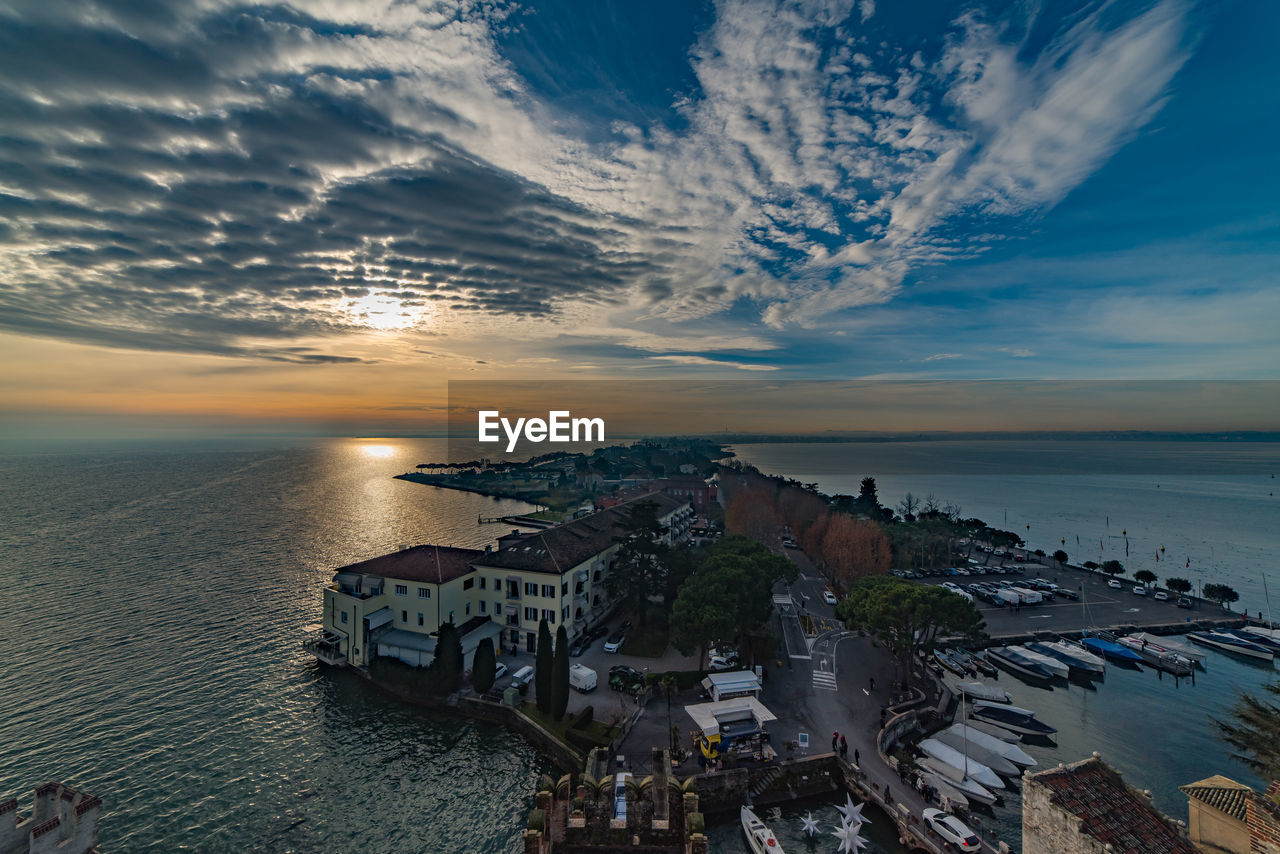 High angle view of city by sea against sky