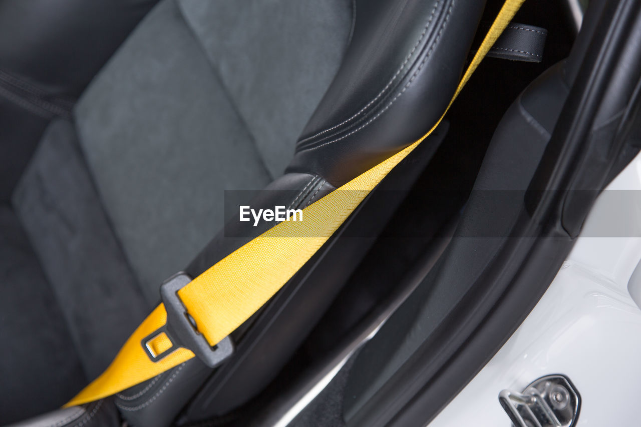 Close-up of yellow seat belt in car