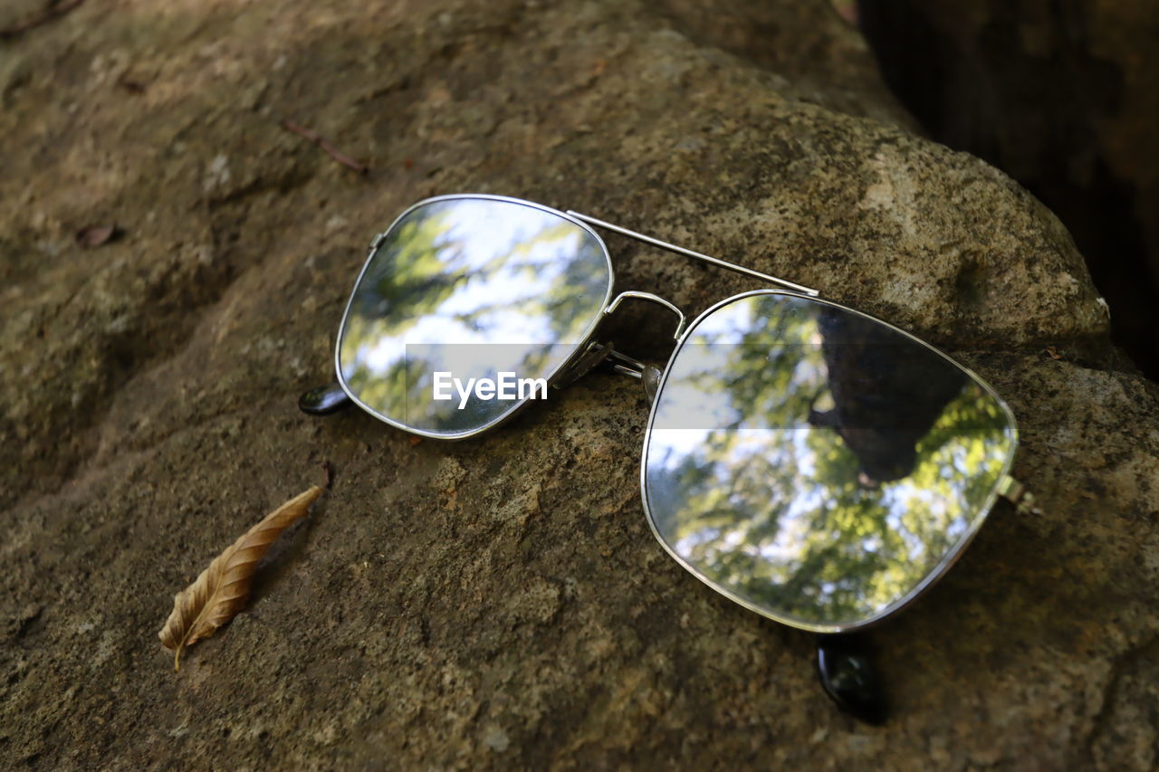 rock, nature, reflection, close-up, fashion, glasses, fashion accessory, no people, macro photography, outdoors, day, jewelry, land, sunglasses, focus on foreground, shiny, personal accessory, single object