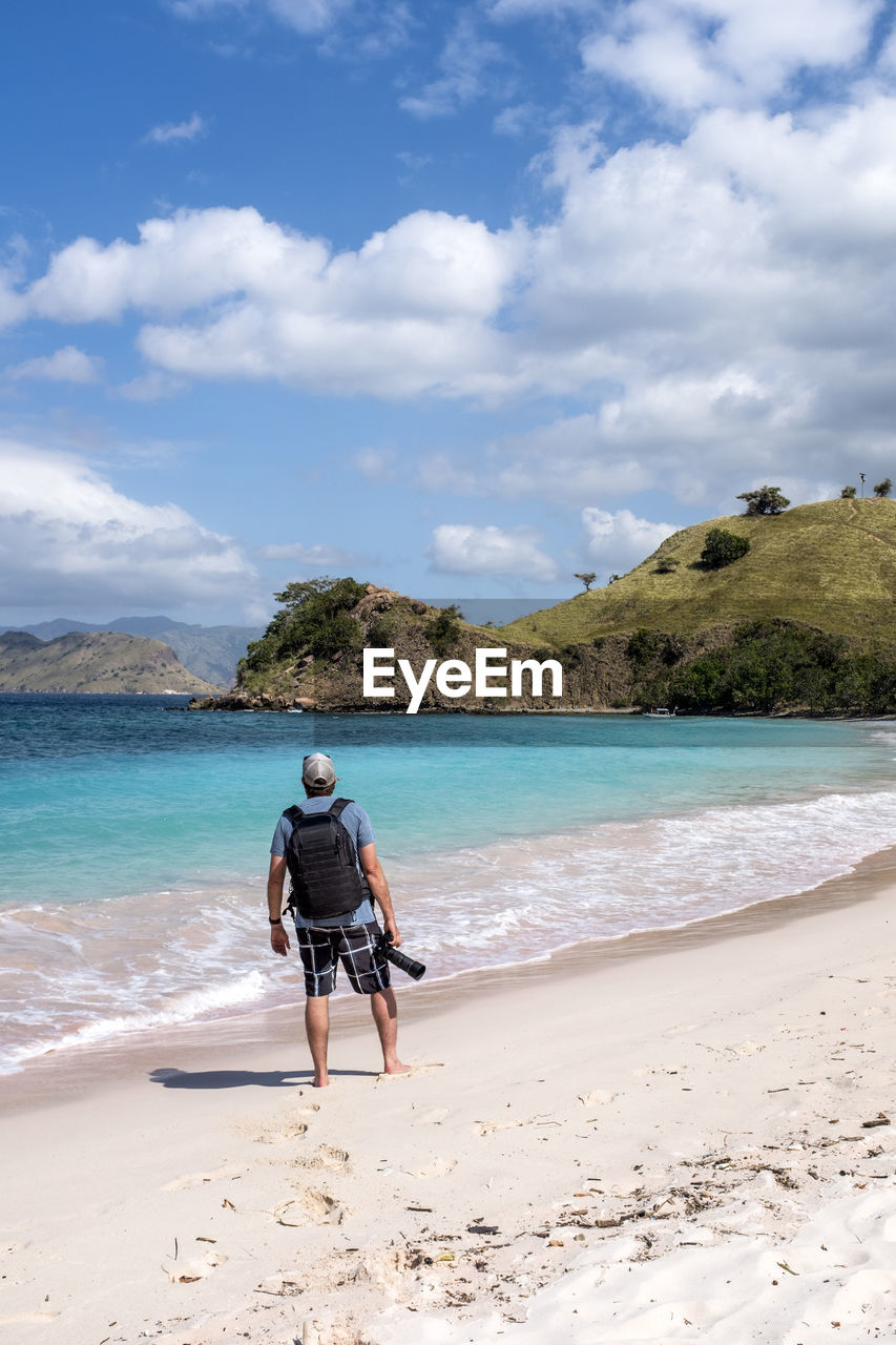 A photographer on pink beach in komodo national park, indonesia.