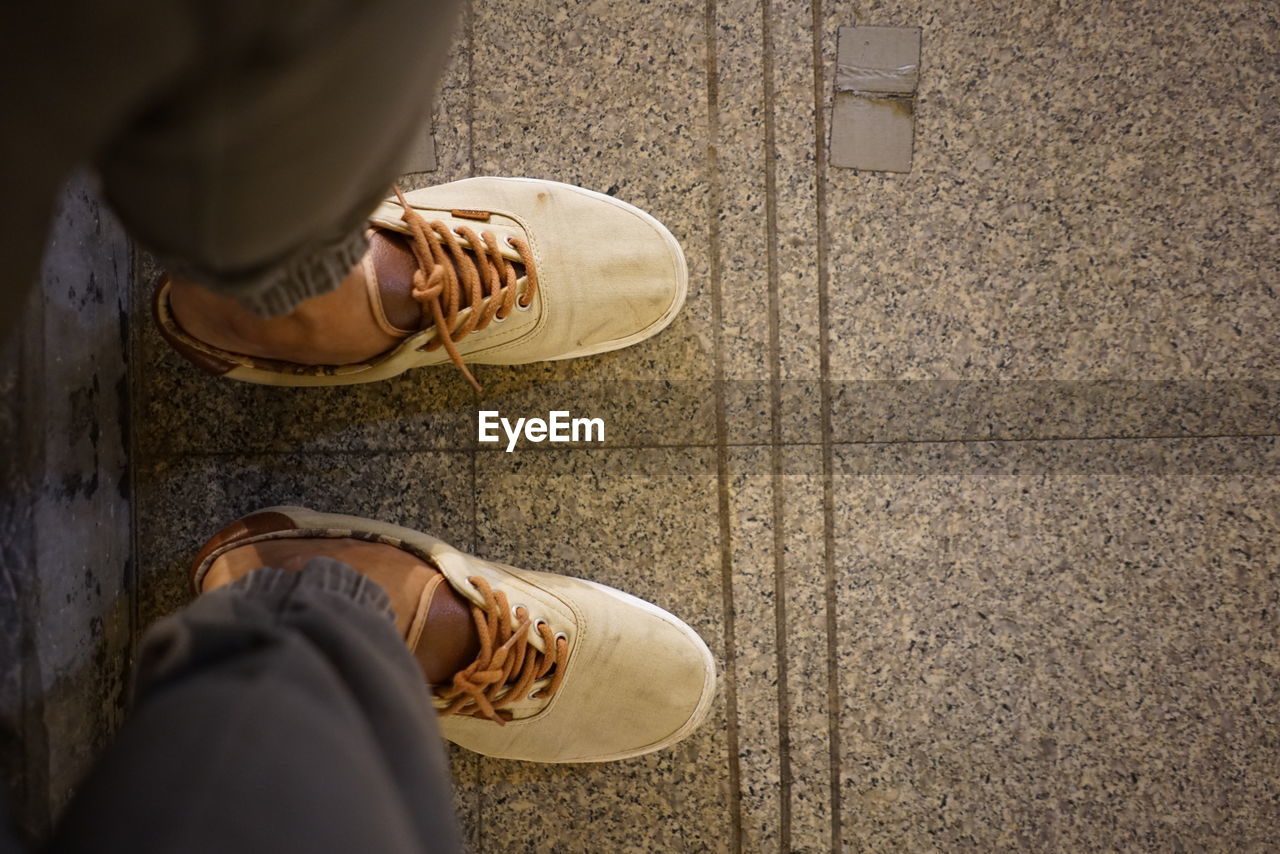 Low section of person on tiled floor