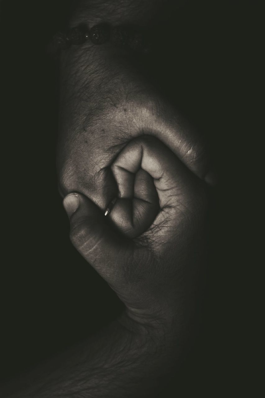 CLOSE-UP OF MAN WITH HAND ON BLACK BACKGROUND