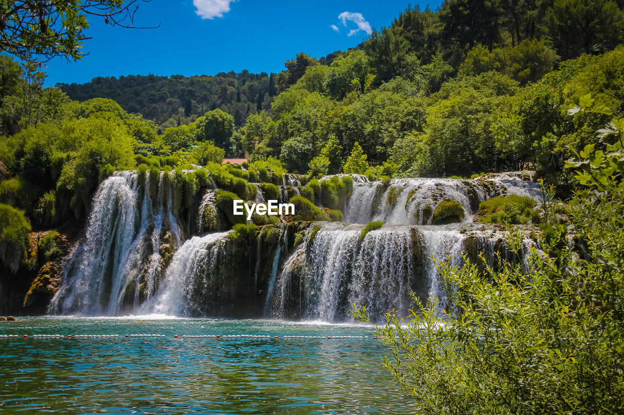 SCENIC VIEW OF WATERFALL AGAINST TREES