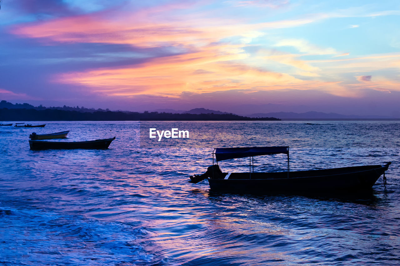 BOAT MOORED ON SEA AGAINST SKY