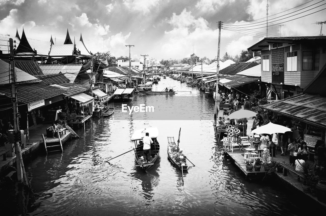 HIGH ANGLE VIEW OF PEOPLE IN RIVER AGAINST BUILDINGS