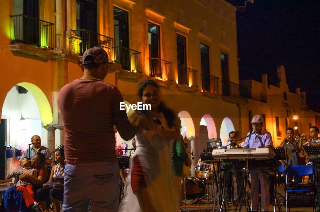 PEOPLE ON ILLUMINATED CITY AT NIGHT