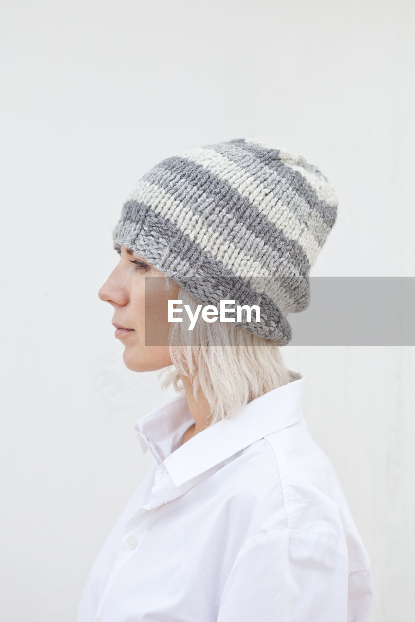 Woman wearing knit hat against white background