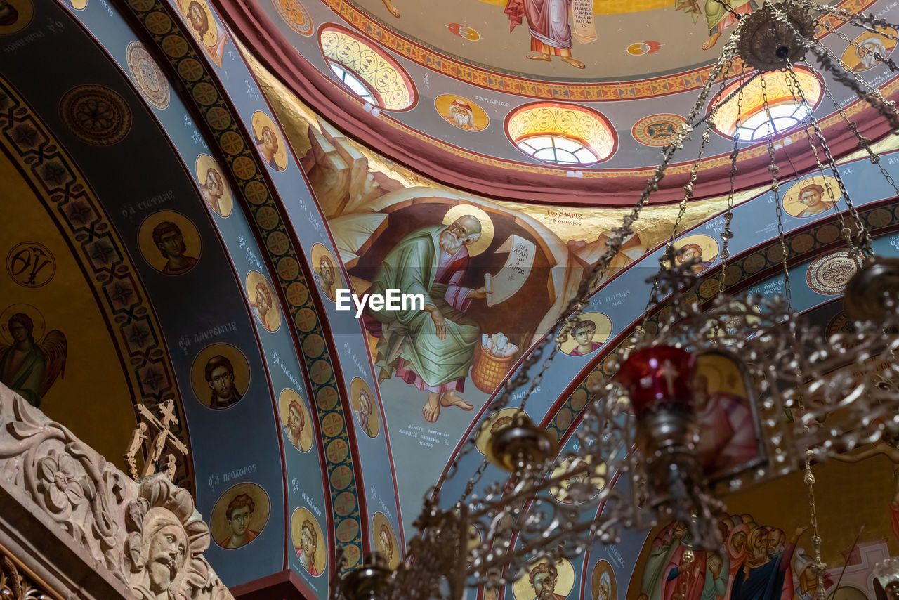 LOW ANGLE VIEW OF STAINED GLASS CEILING AT TEMPLE