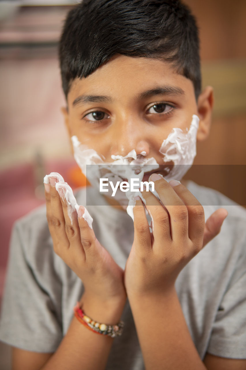 Close-up portrait of boy holding camera