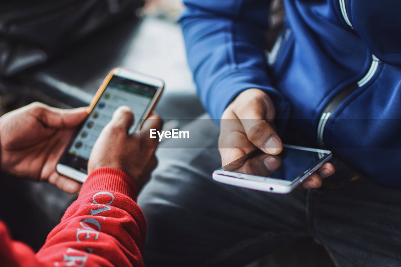 MIDSECTION OF MAN HOLDING SMART PHONE