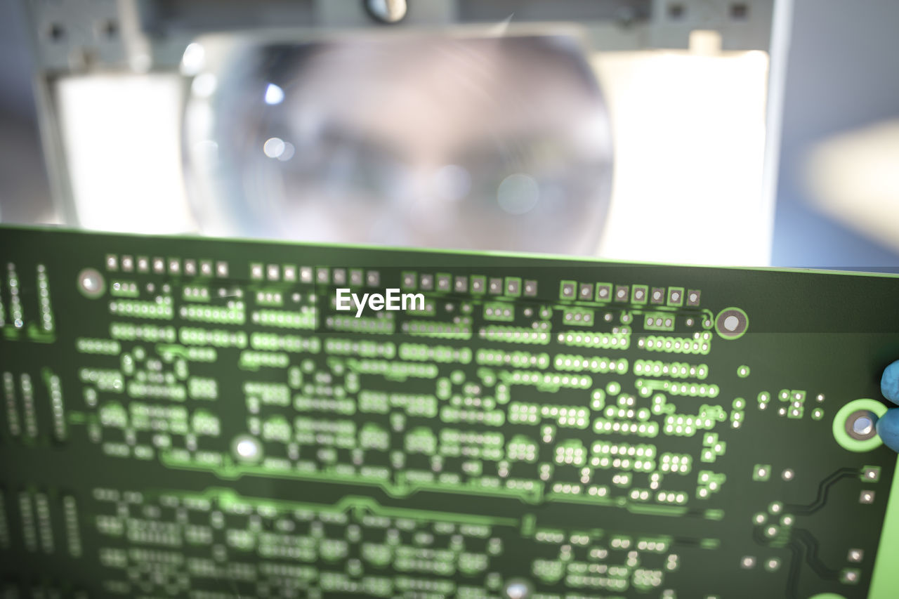 Technician examining motherboard with magnifying glass