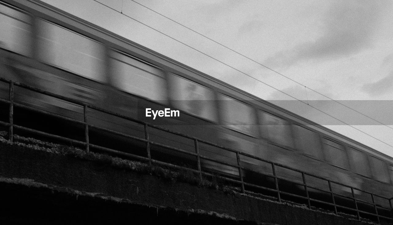 LOW ANGLE VIEW OF TRAIN AGAINST BUILDINGS IN SKY