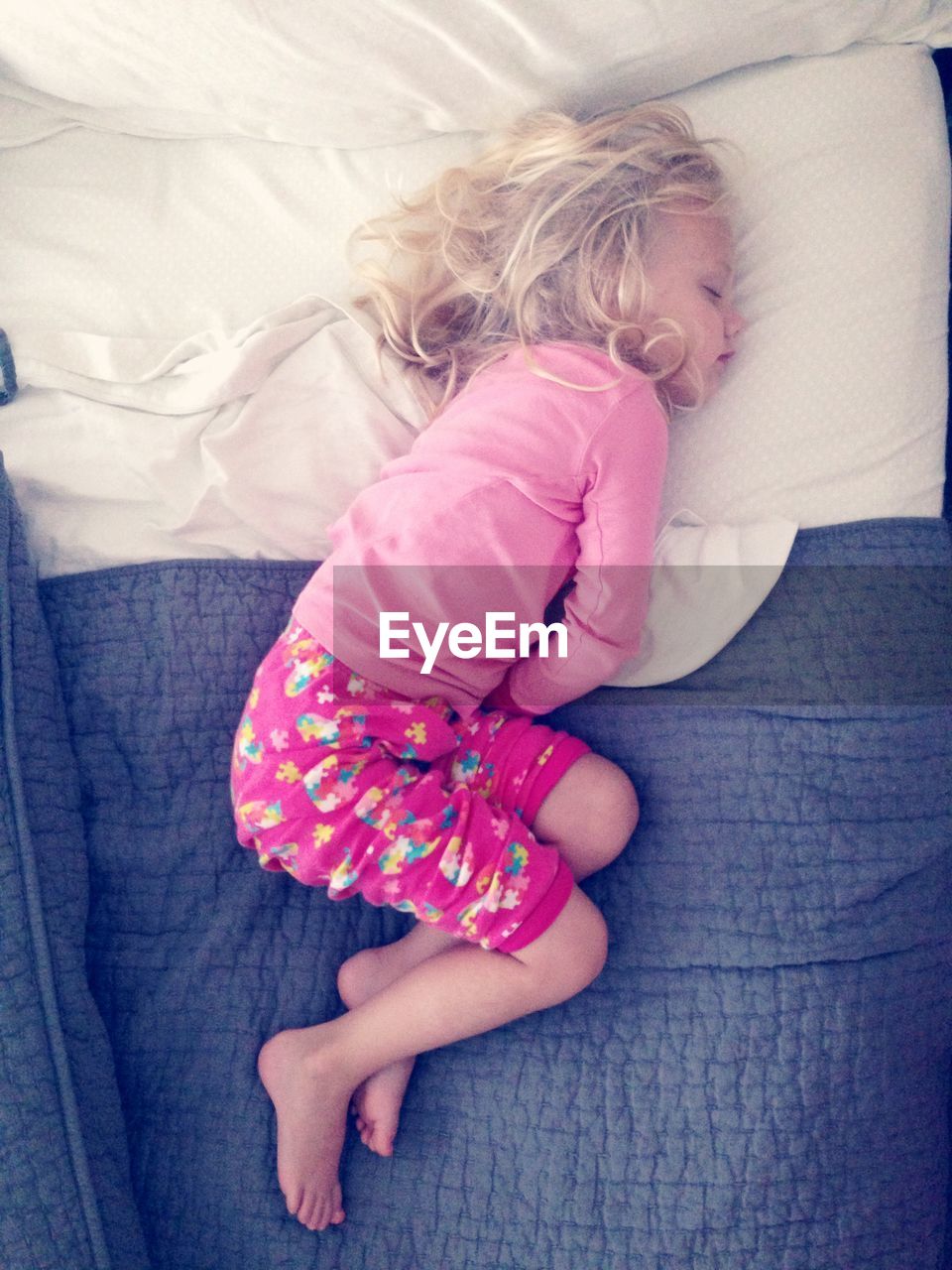 Directly above shot of girl sleeping on bed