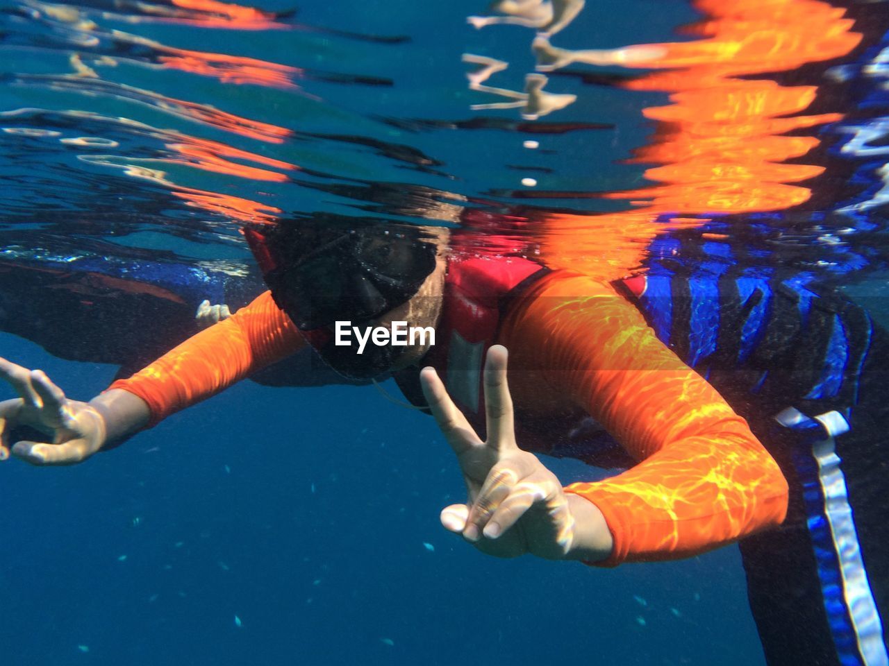 Portrait of young man gesturing peace sign while snorkeling in sea