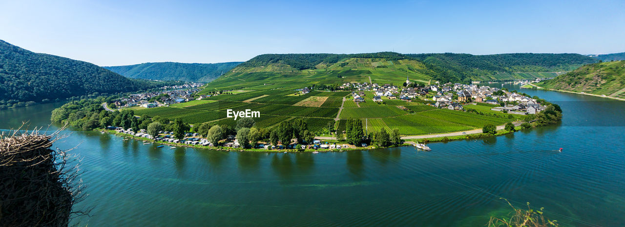 Scenic view of lake and mountains against clear blue sky