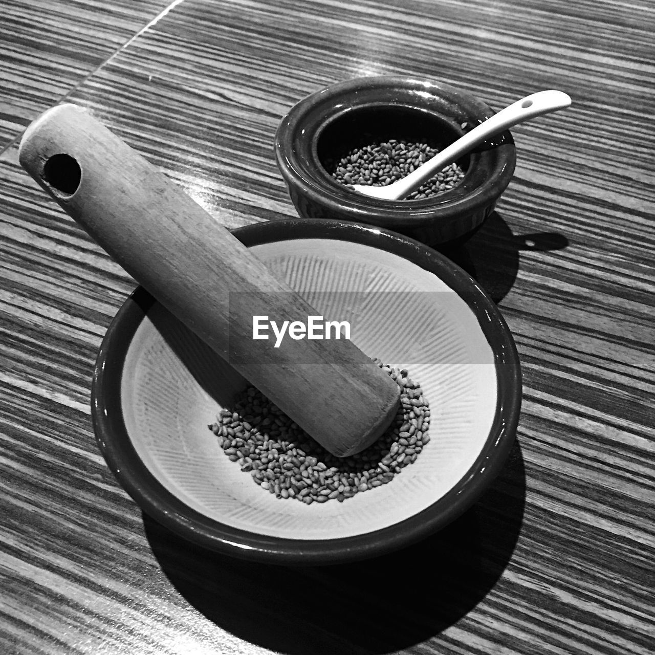 High angle view of mortar and pestle with grains by bowl on table