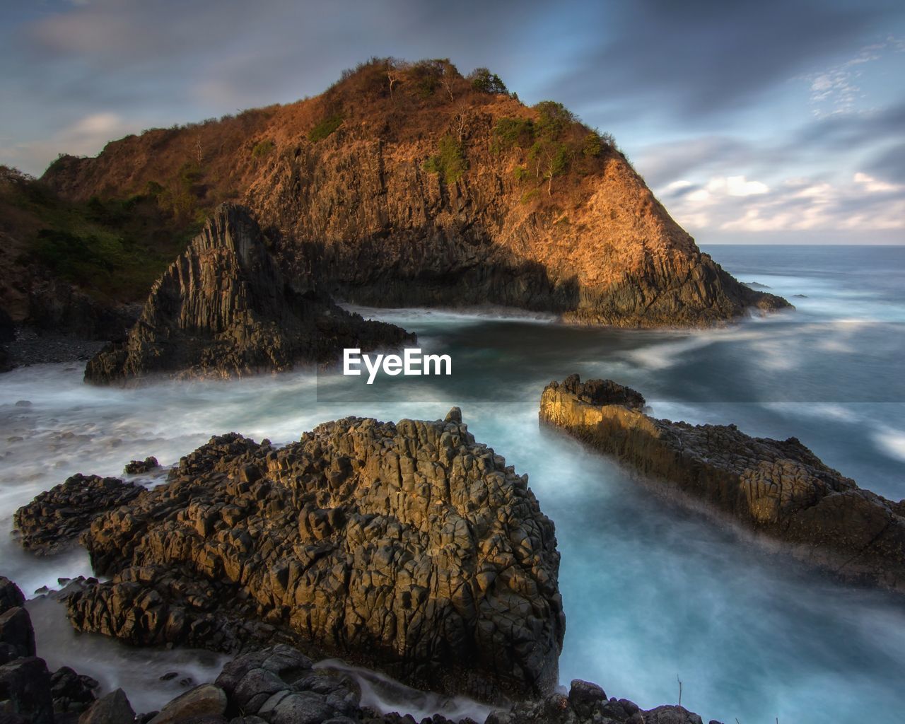 Scenic view of rocks in sea against sky
