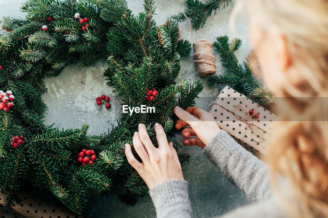 High angle view of woman making wreath on table