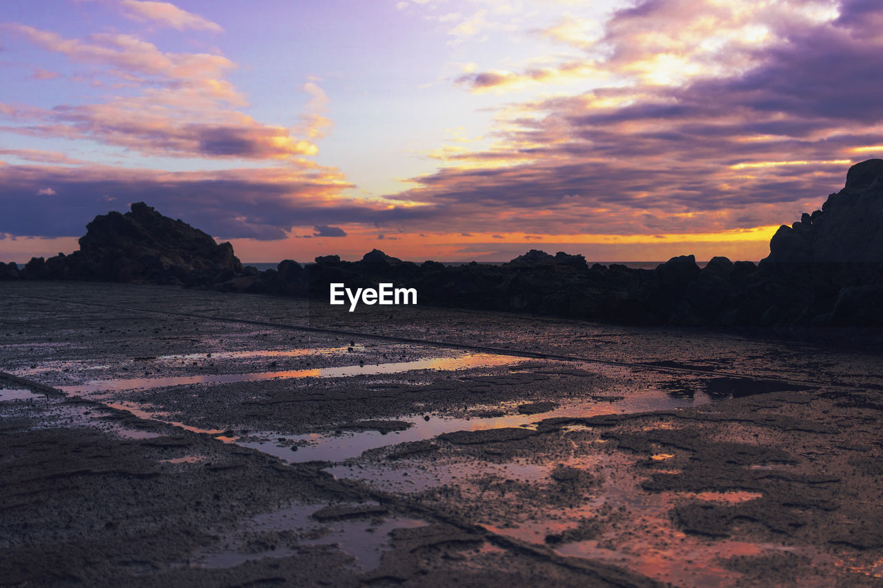 SCENIC VIEW OF LAND AGAINST SKY DURING SUNSET