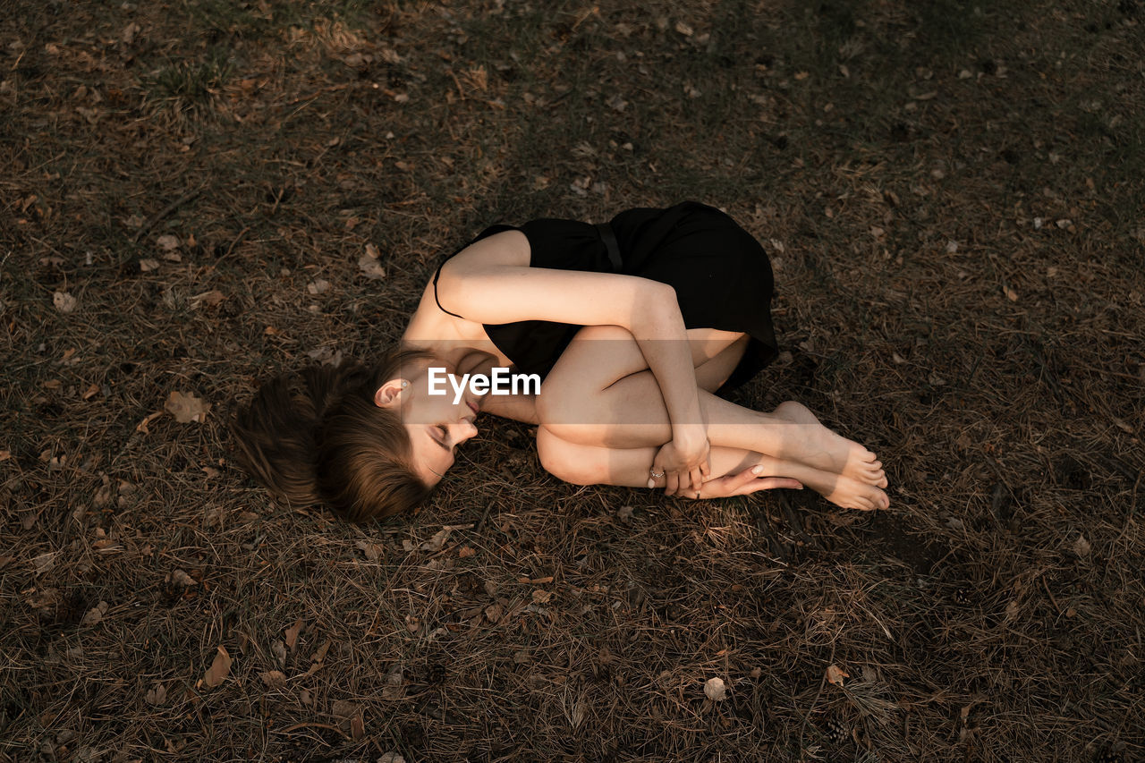 High angle view of woman lying on land