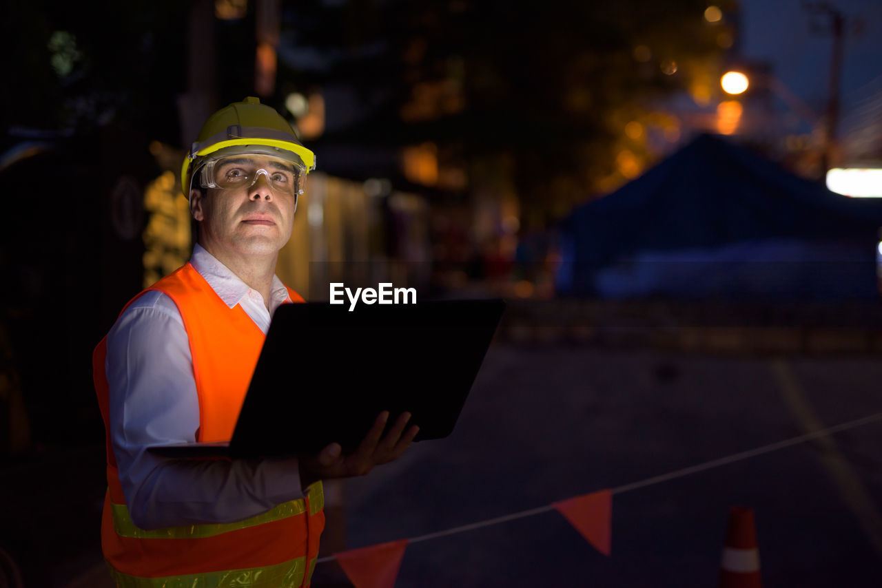 LOW ANGLE VIEW OF MAN WORKING WITH LAPTOP