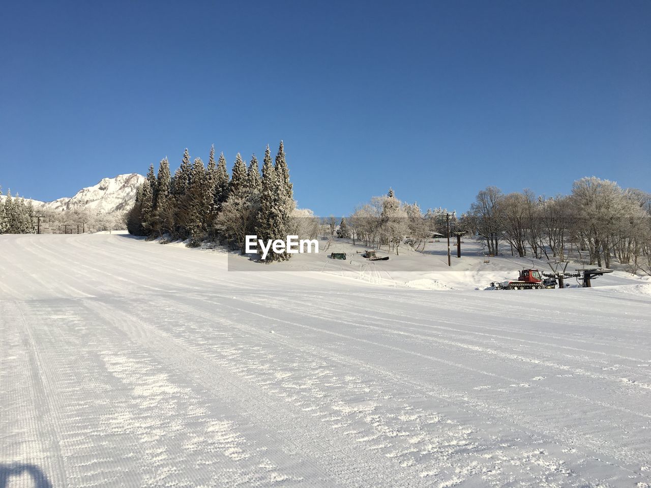 Snow covered land against clear sky