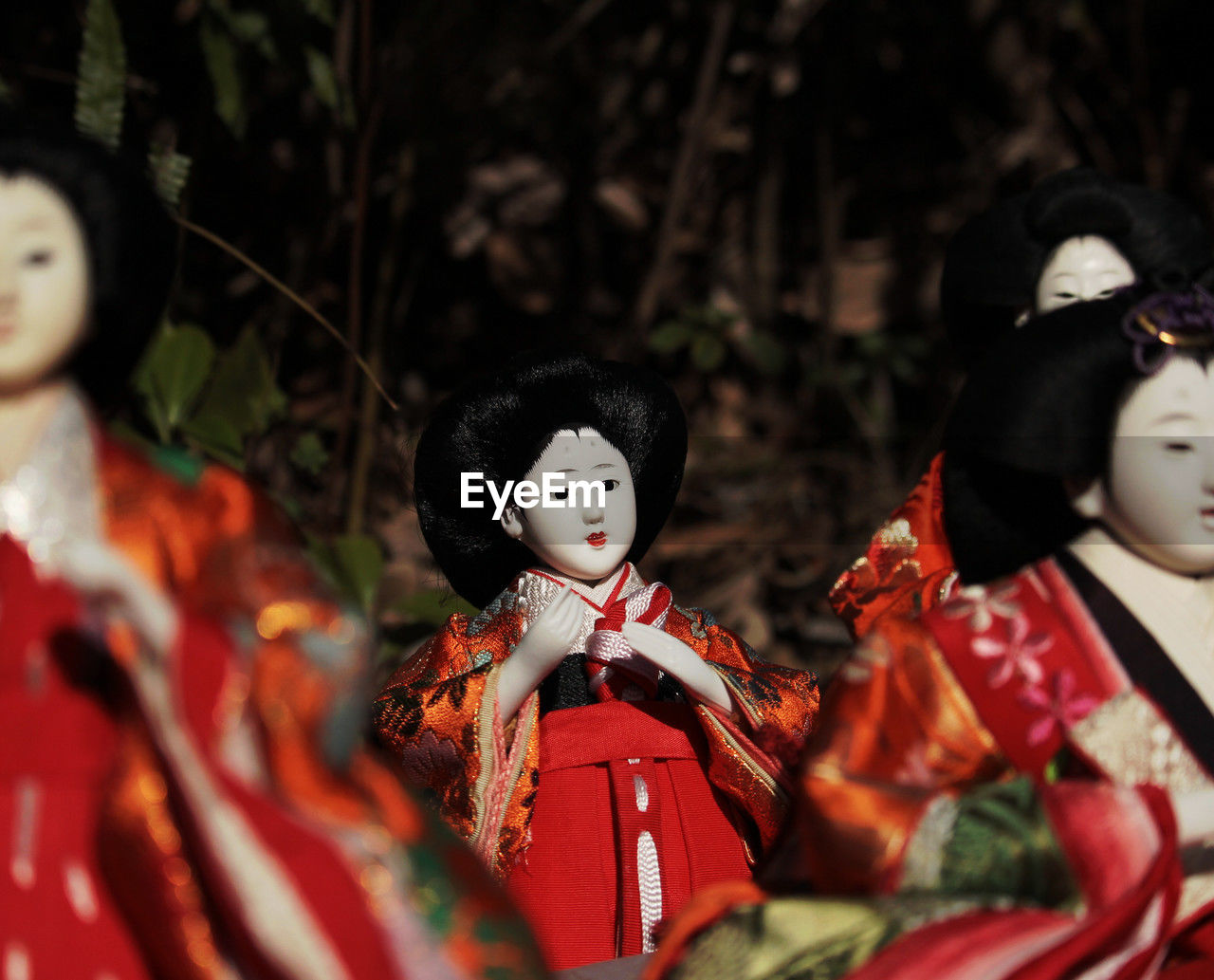 human representation, doll, representation, red, toy, culture, male likeness, tradition, female, selective focus, celebration, no people, clothing, traditional clothing, creativity, figurine, disguise, costume, mask - disguise, outdoors, spooky